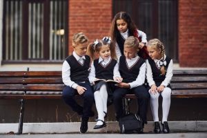 school-kids-uniform-that-sits-outdoors-bench-with-notepad_146671-27918